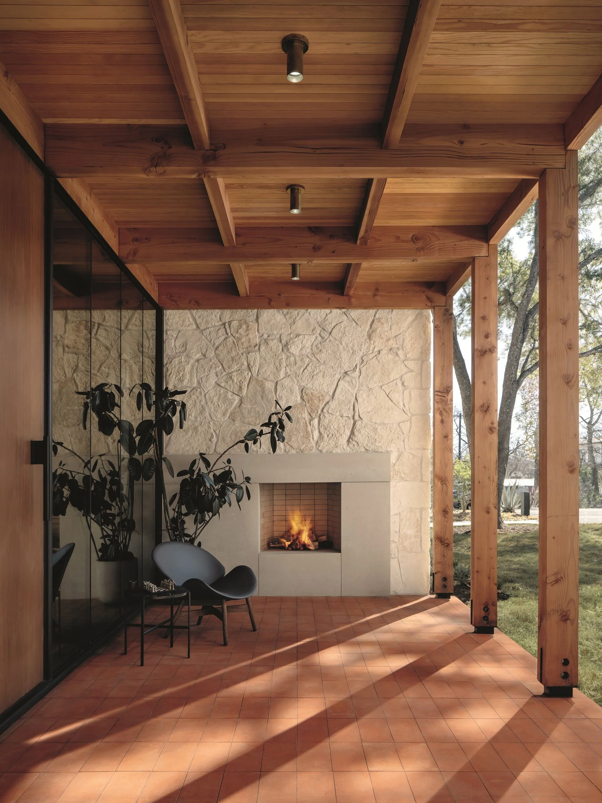 An exterior fireplace under a wood porch