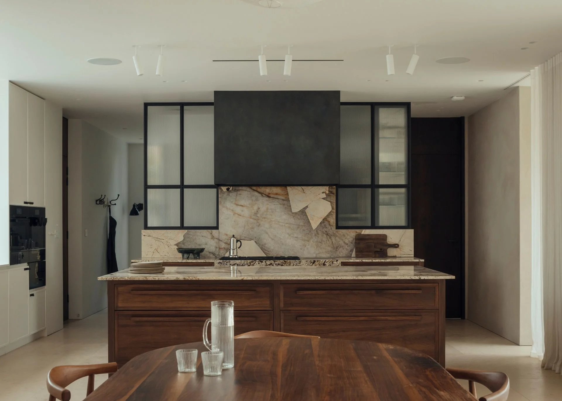 A neutral wooden kitchen with multiple statement surfaces