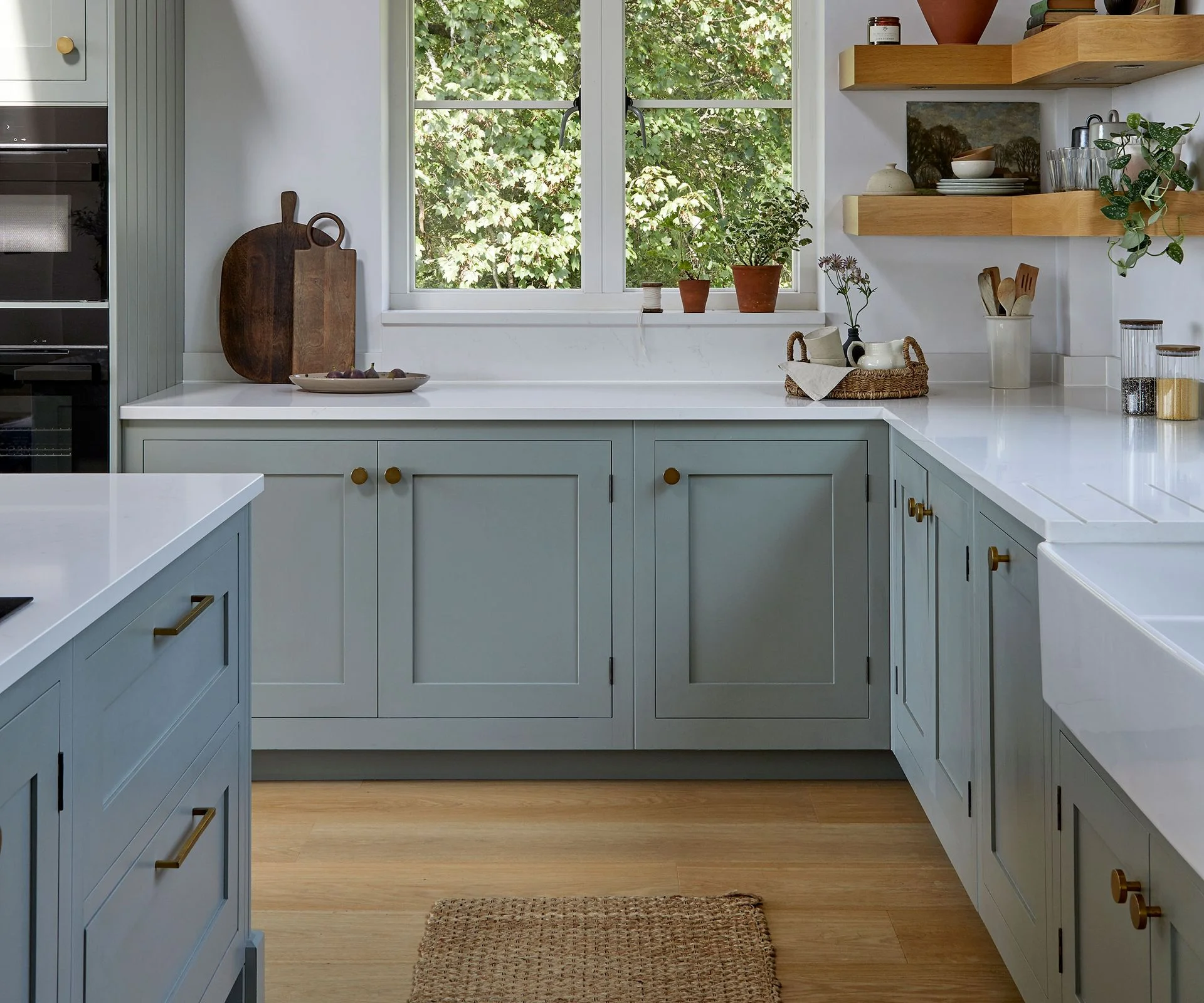 pale blue Shaker kitchen with wooden knobs and white worktops