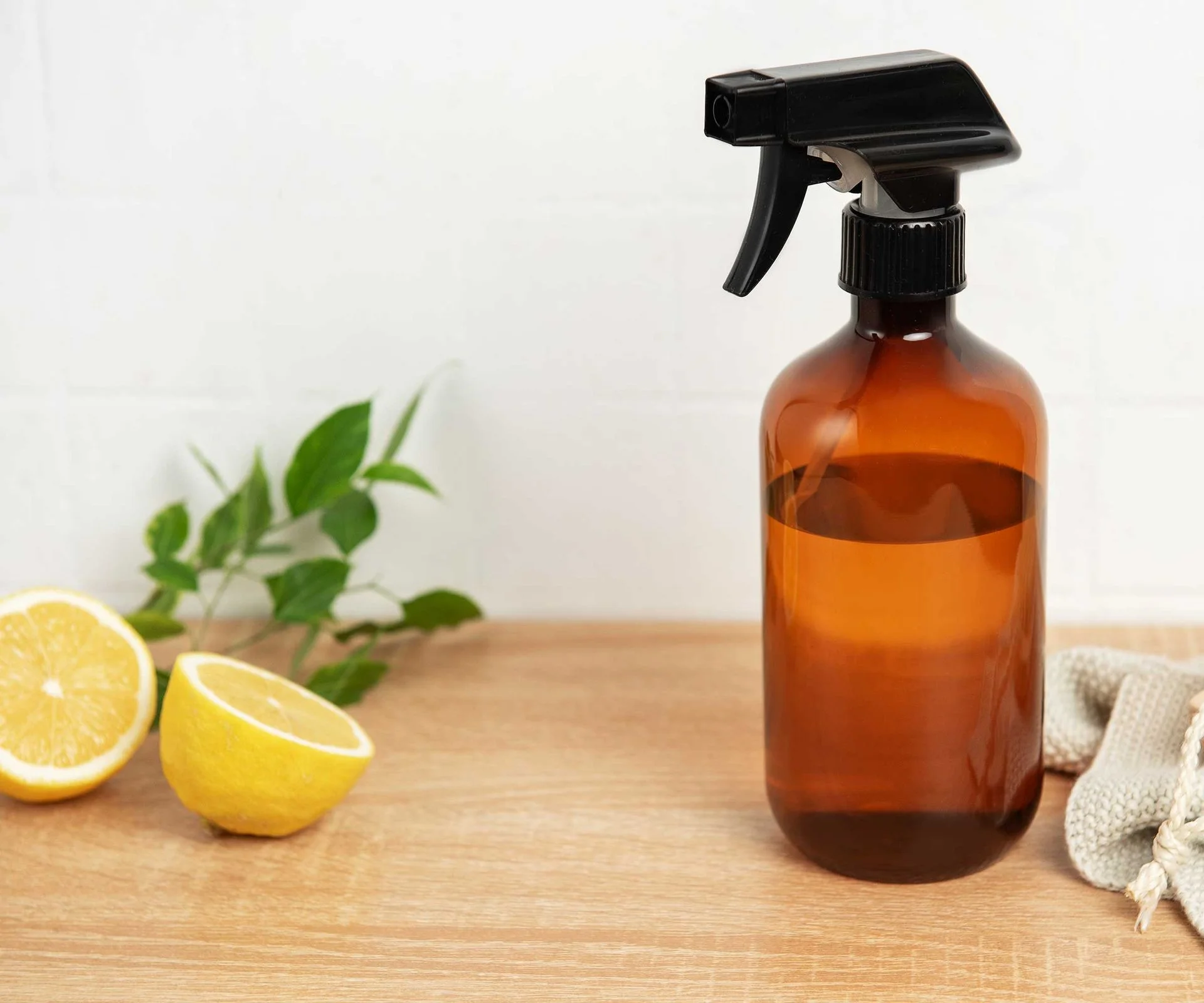 homemade cleaning and pest spray next to a sliced lemon