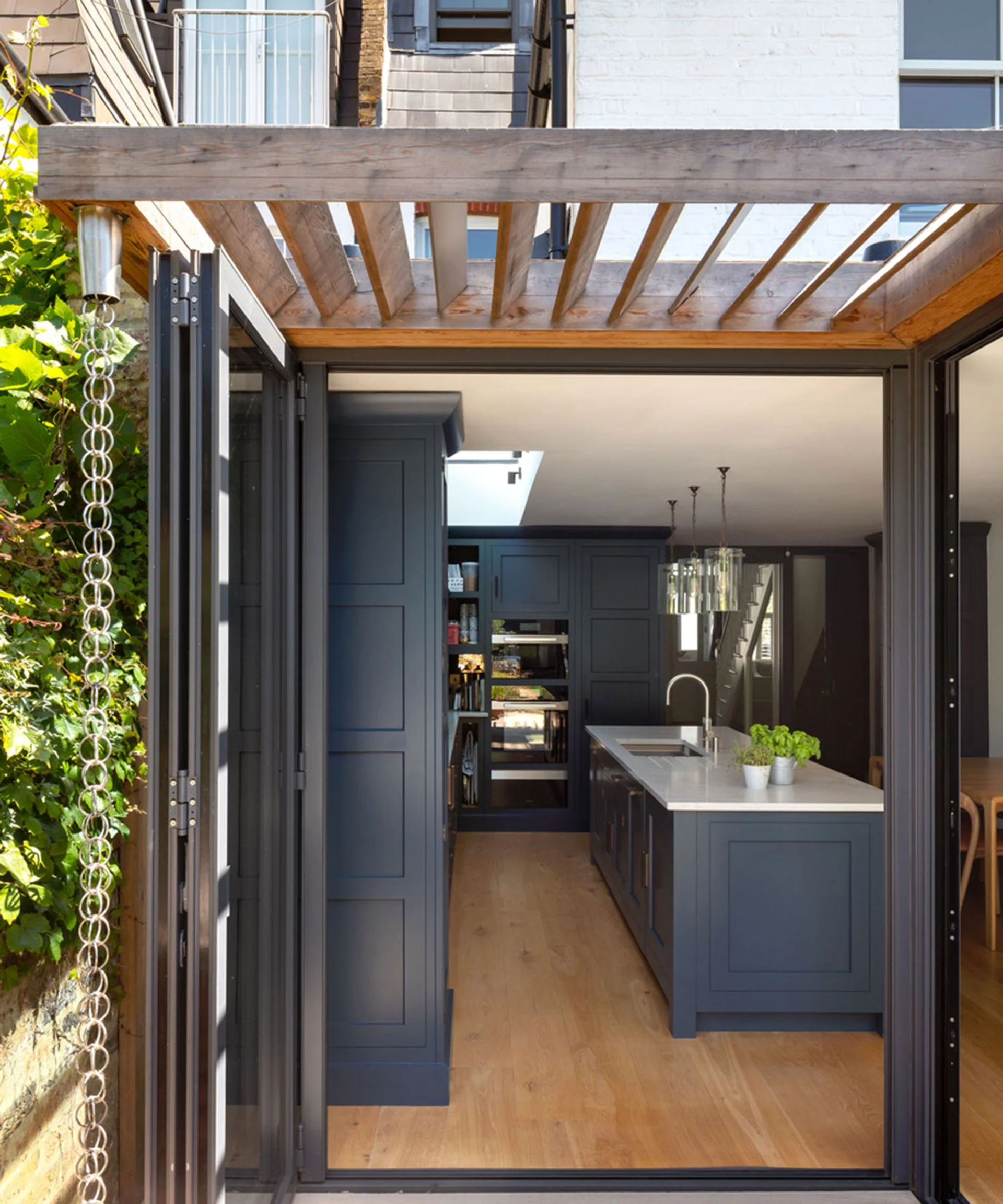 kitchen extension with blue kitchen and bifold doors with wooden brise soleil