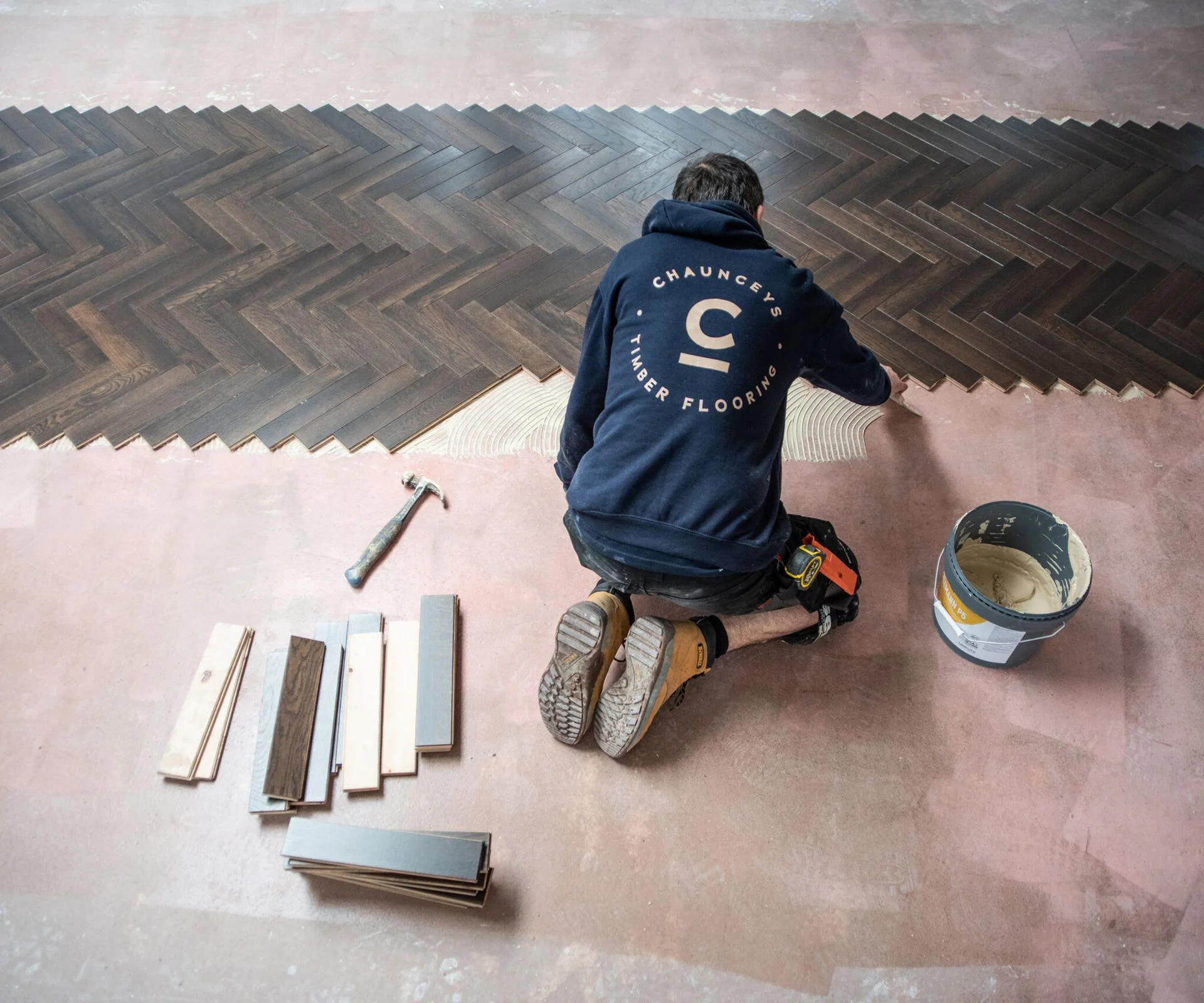 man installing herringbone engineered wooden flooring