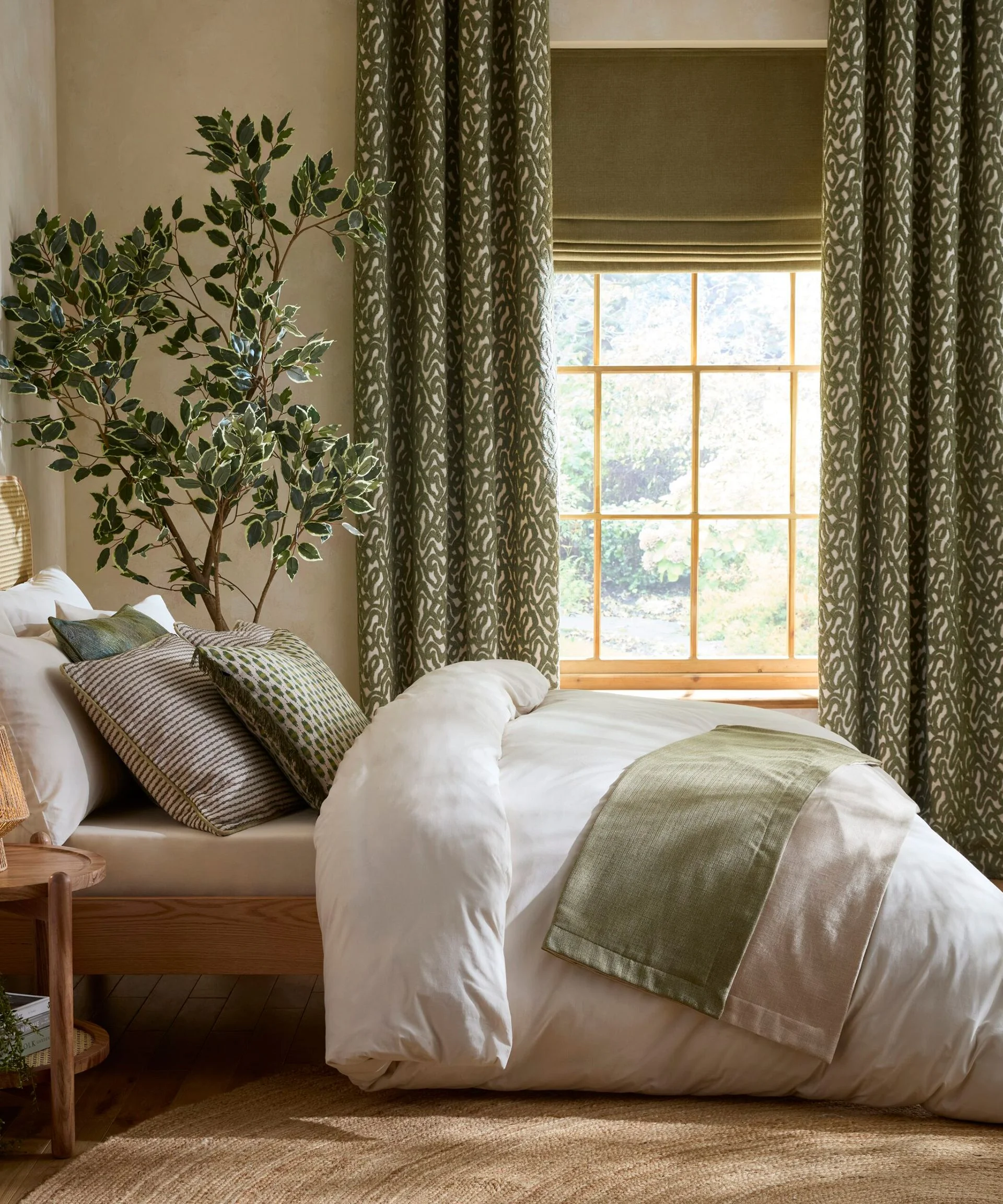 bedroom with long green patterned curtains and green velvet blind