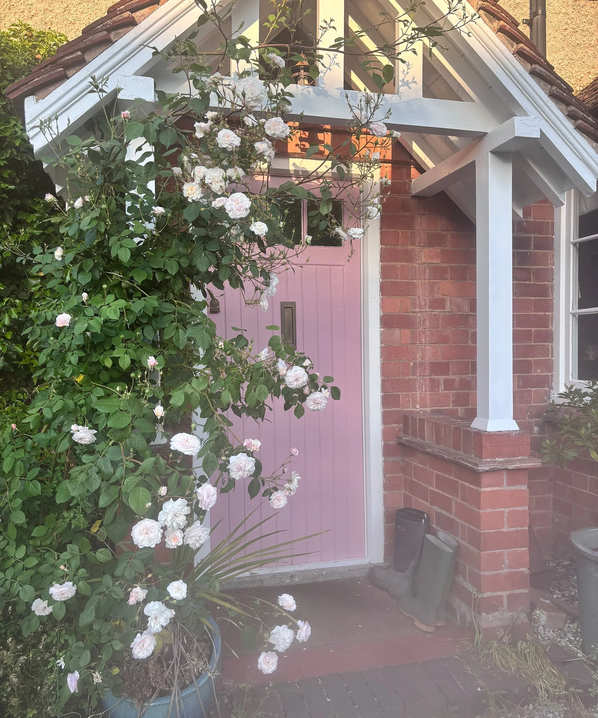 pink front door with small porch with pitched roof
