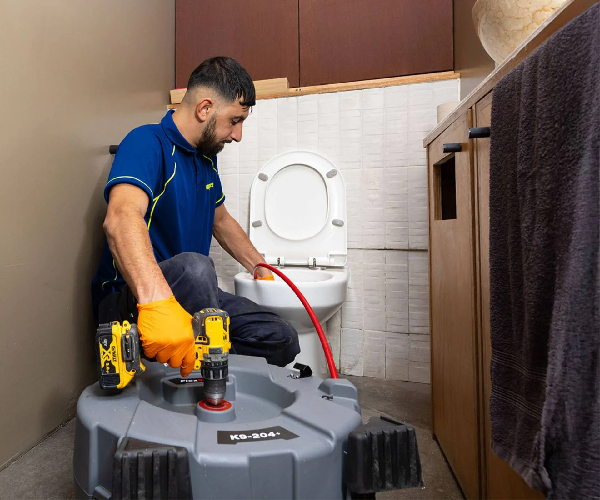 Man unblocking toilet with specialist equipment