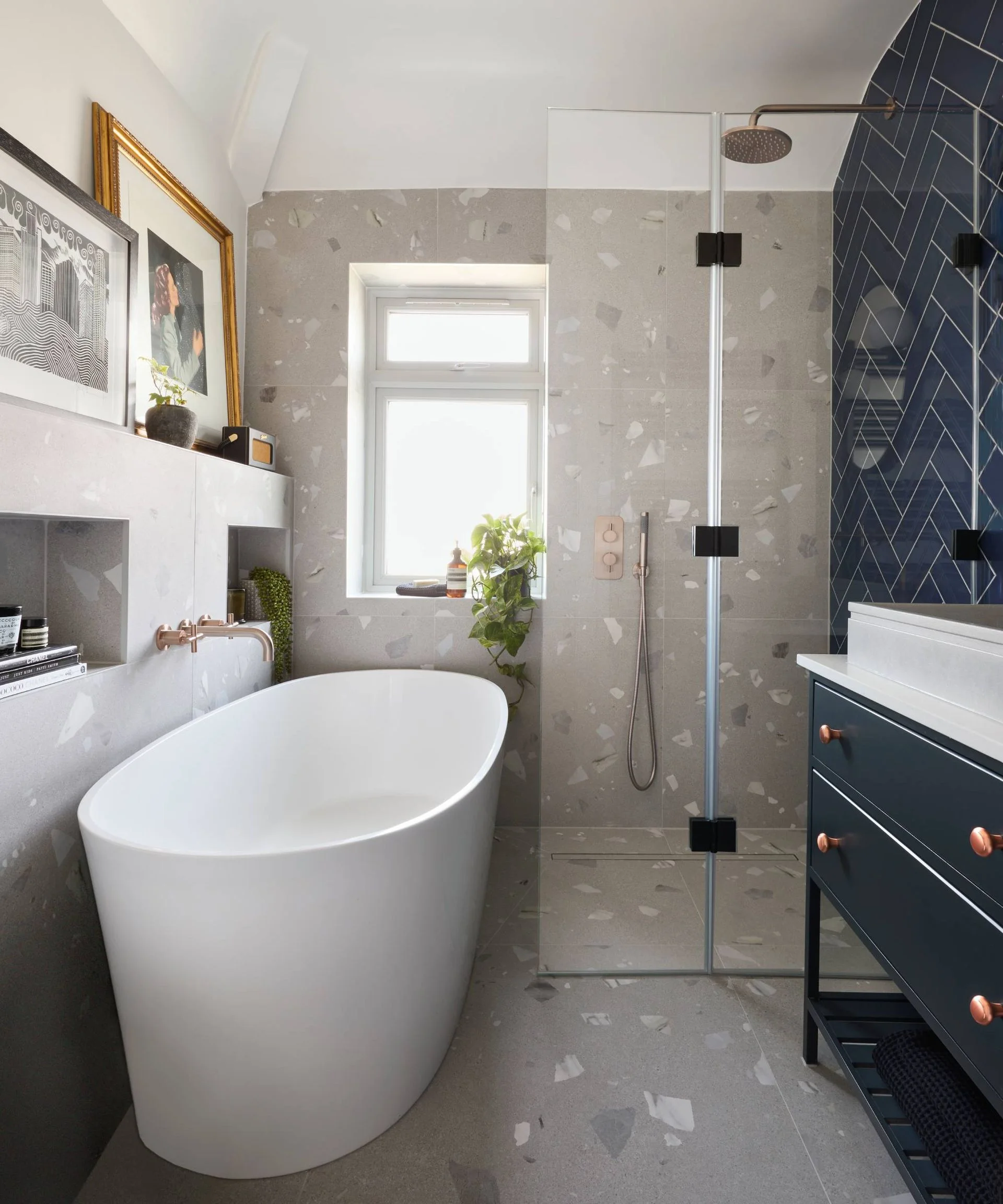 Modern freestanding bath and walk-in shower in bathroom with concrete and navy
