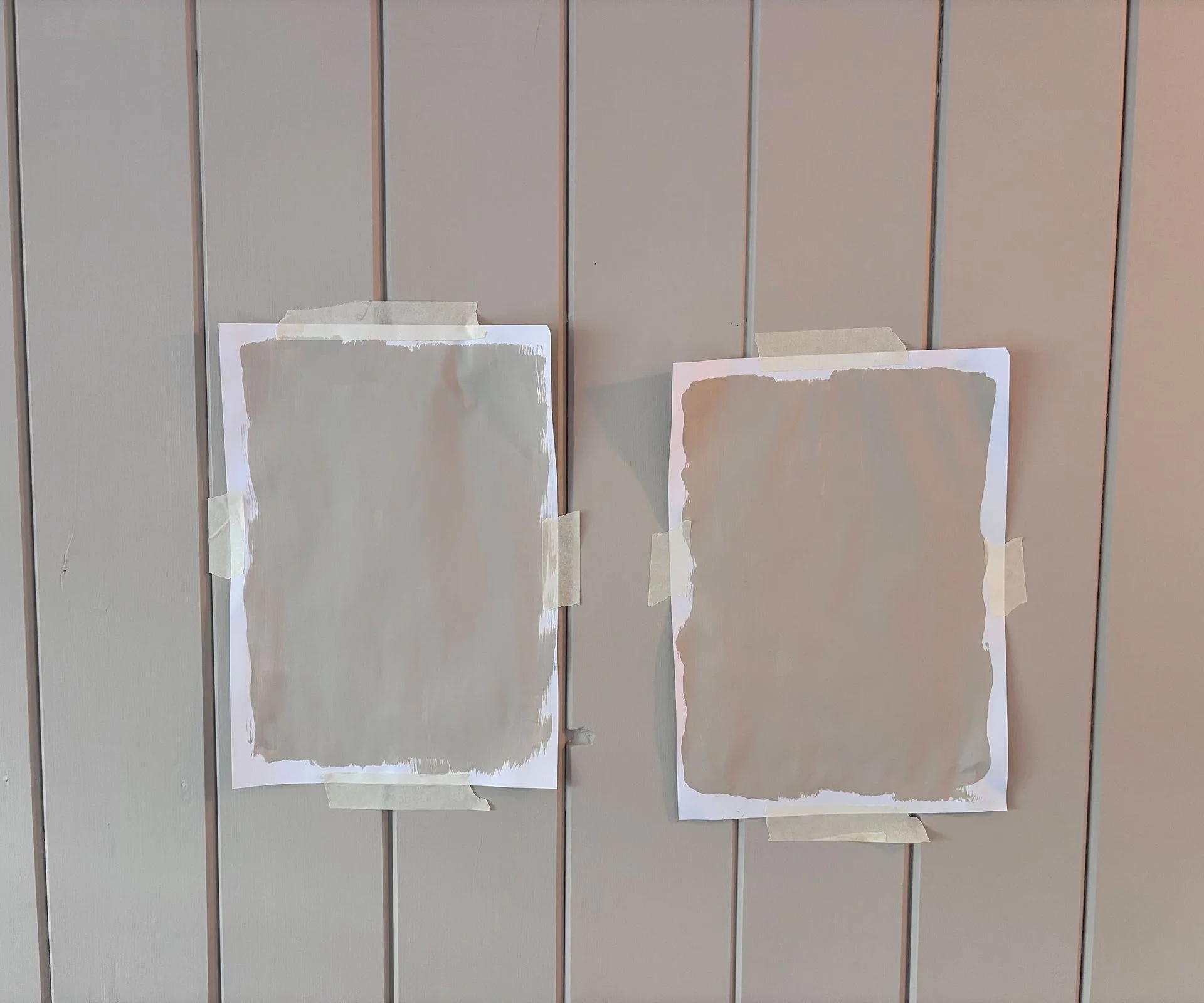 two paint samples on wooden wall paneling
