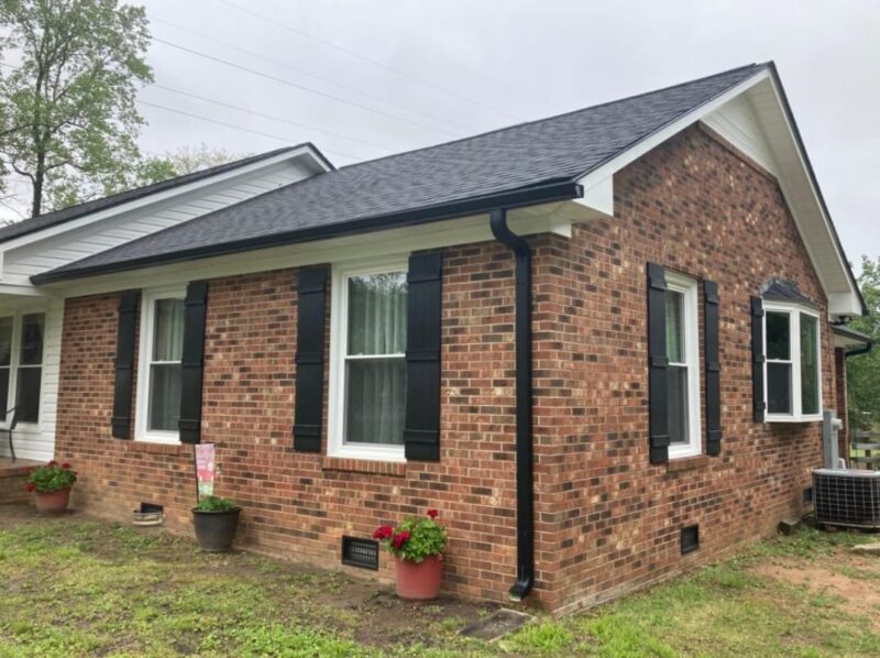 Brick House with Black Window Shutters and Gutters